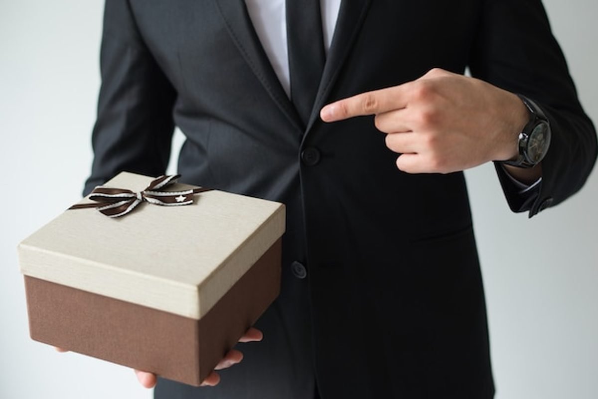 Corporate gifting etiquette at an international business event, a host presenting a gift box