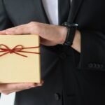 How to choose gifts for foreign delegates, a business host presenting a wrapped gift box