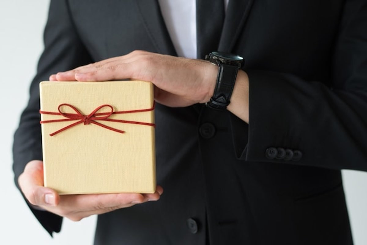 How to choose gifts for foreign delegates, a business host presenting a wrapped gift box