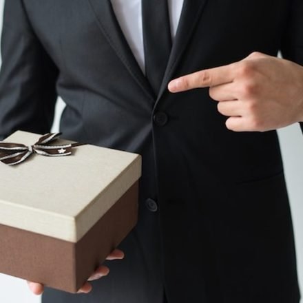 Corporate gifting etiquette at an international business event, a host presenting a gift box