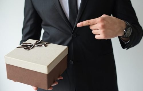 Corporate gifting etiquette at an international business event, a host presenting a gift box
