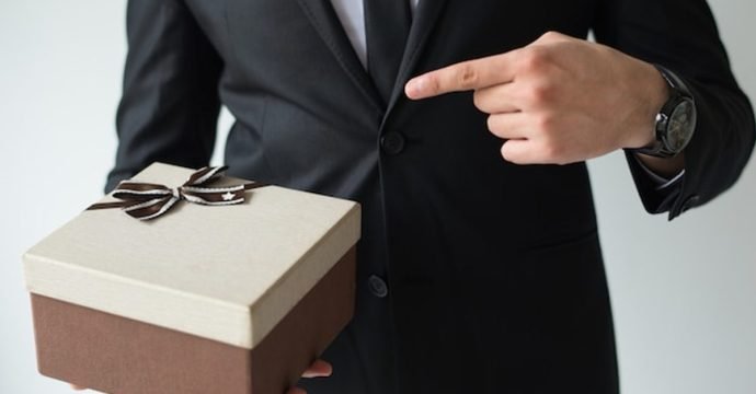 Corporate gifting etiquette at an international business event, a host presenting a gift box