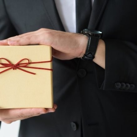 How to choose gifts for foreign delegates, a business host presenting a wrapped gift box
