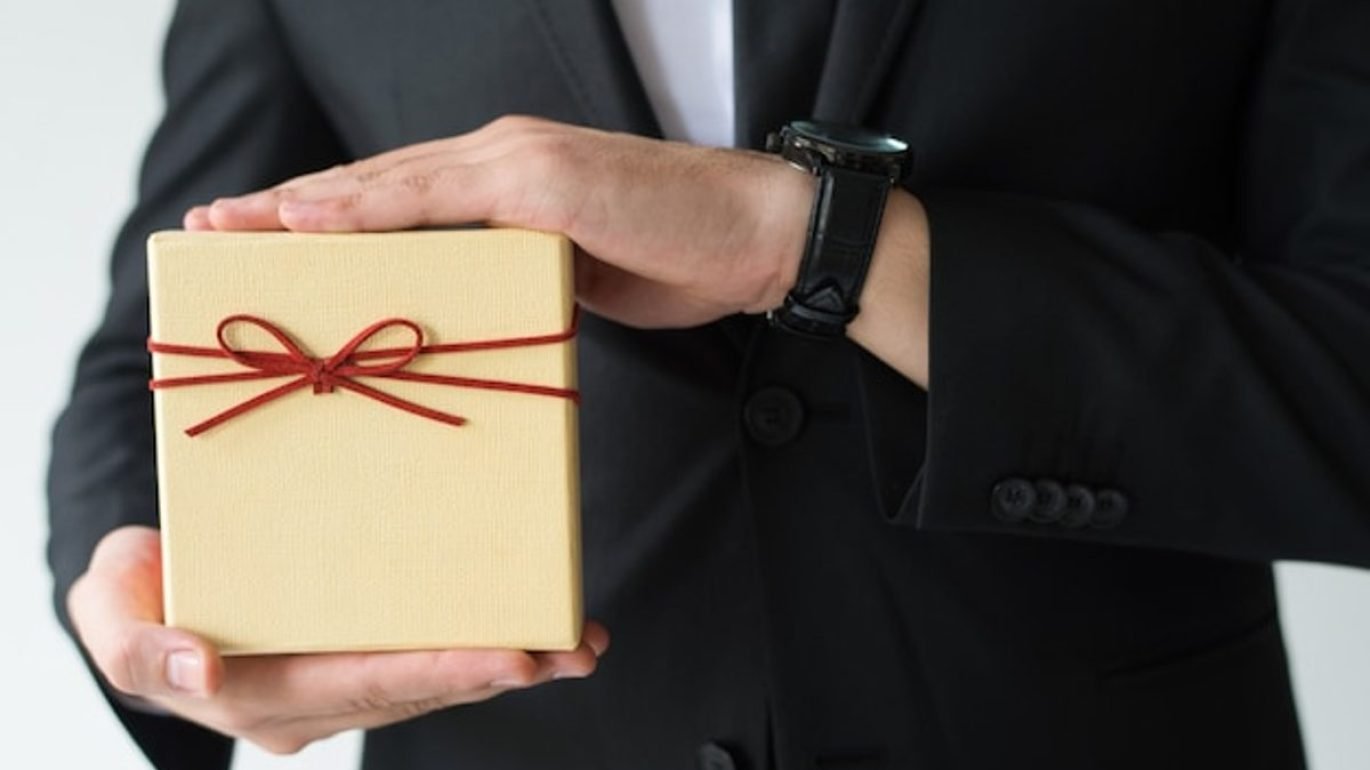 How to choose gifts for foreign delegates, a business host presenting a wrapped gift box